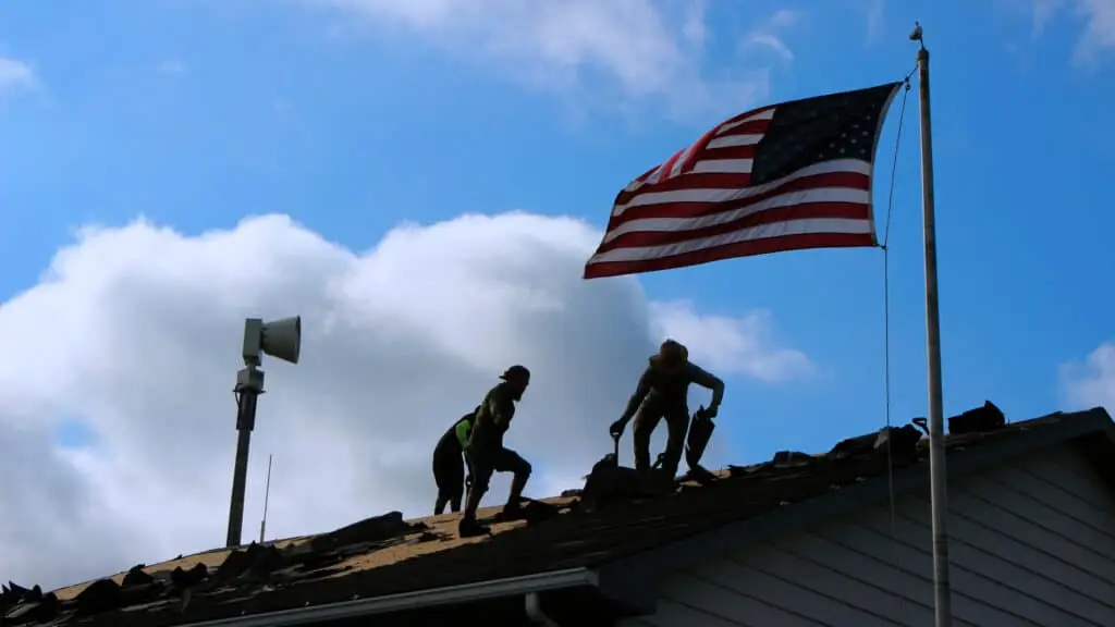 Roofers working. All Craft donates the labor on a new roof for the Wabash Ambulance Building.