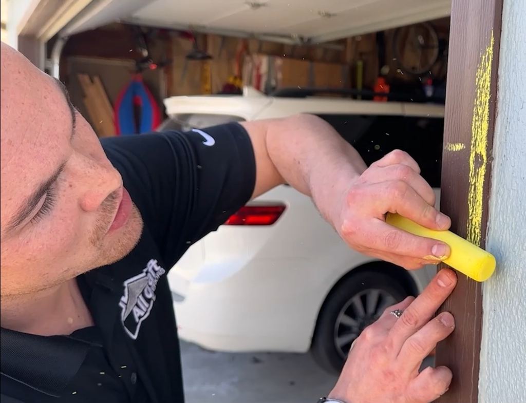 All Craft Exteriors estimator marking hail damage on home siding