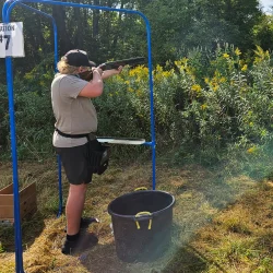 Youth trap shooter aiming and taking a shot during the Rochester Area Builders Youth Sporting Clays Shoot.